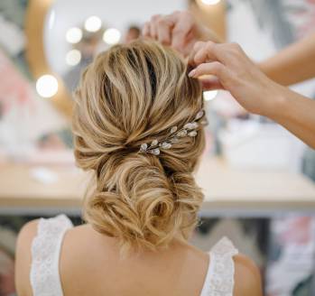 Hairdresser woman weaving braid hair, wedding styling.