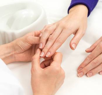 French Manicure process in beauty salon close up of female hands